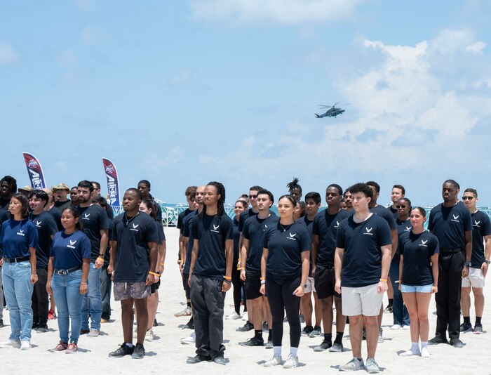 helicopter hovering over group of people standing at attention