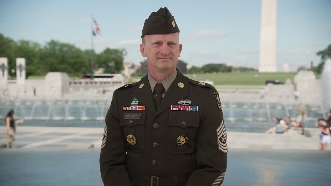 A soldier stands at a monument.