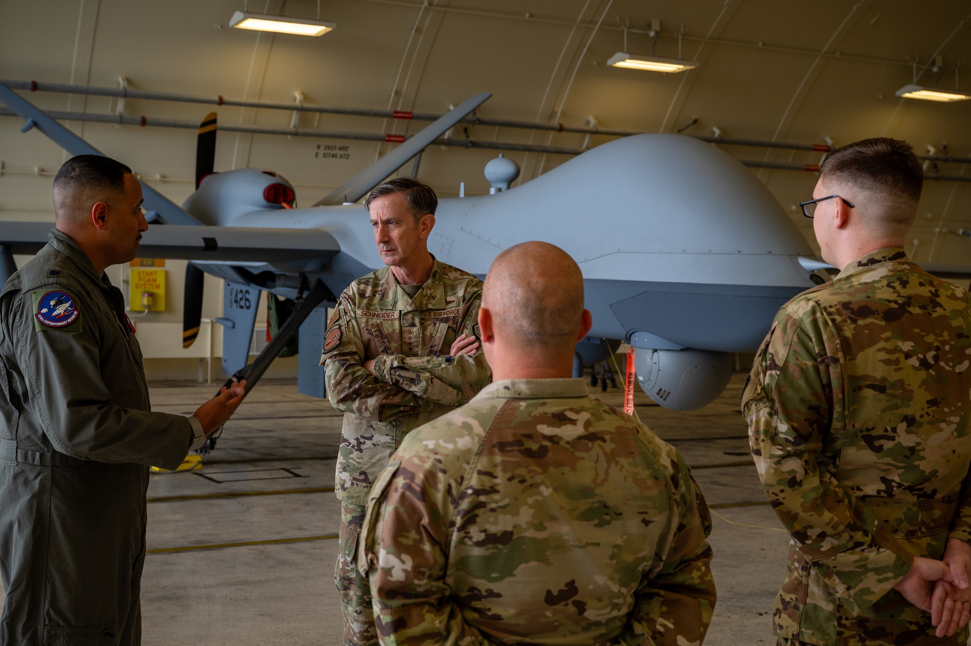 An Airman briefs the PACAF commander in front of an MQ-9 during an immersion tour.