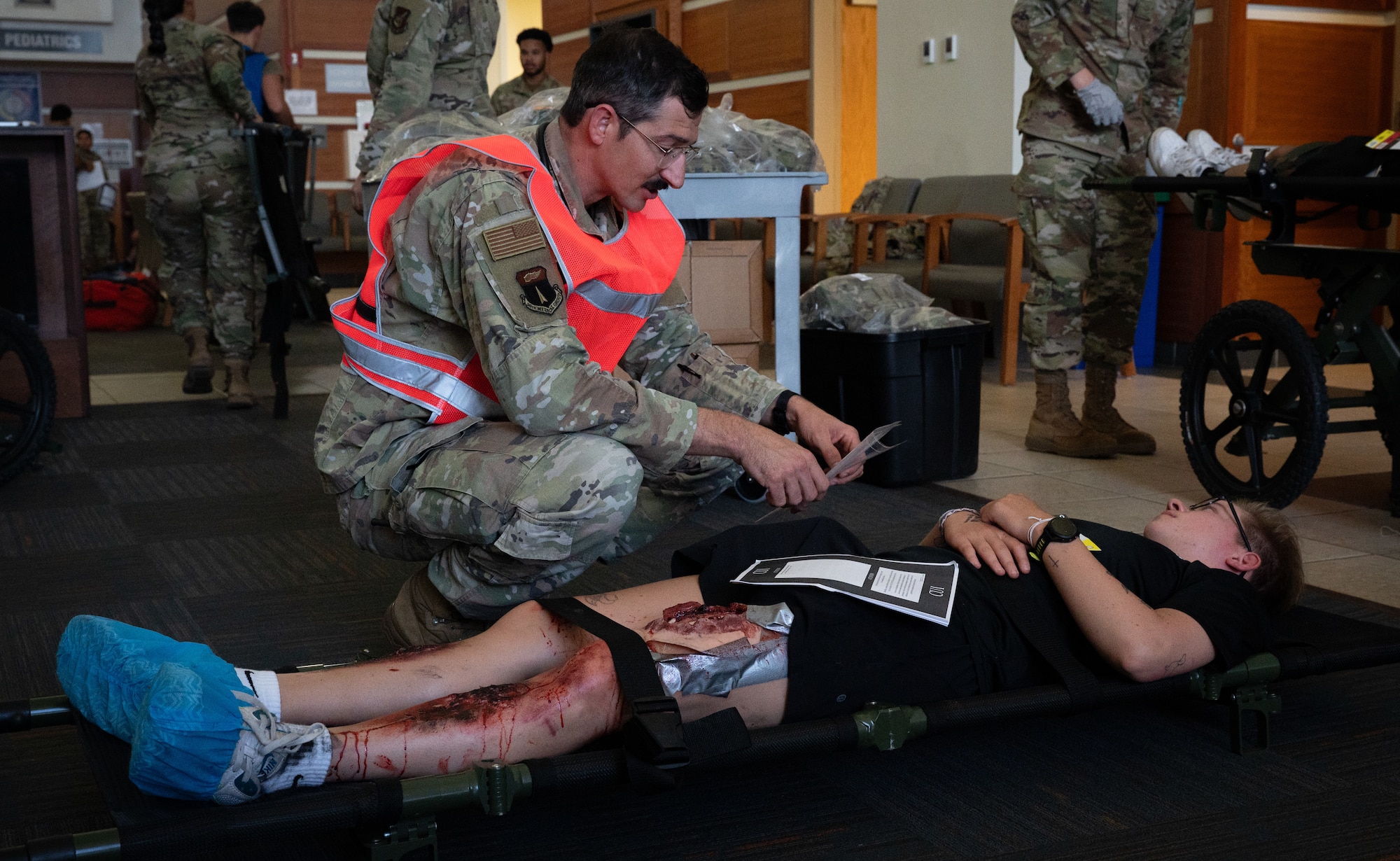 Major Jacob Bessler, 36th Medical Group, checks on a simulated casualty during a Mass Casualty Exercise at Andersen Air Force Base, Guam, May 14, 2025. The 36th MDG hosts many exercises to keep their Airmen ready to fight. This month they decided to drill their Airmen on the processes of a mass casualty. Each process was evaluated by the Wing Inspection Team. These findings would be brought to the chiefs of each division to assess and make the changes needed to be more efficient and effective. (U.S. Air Force photo by Staff Sgt. Pedro Tenorio)