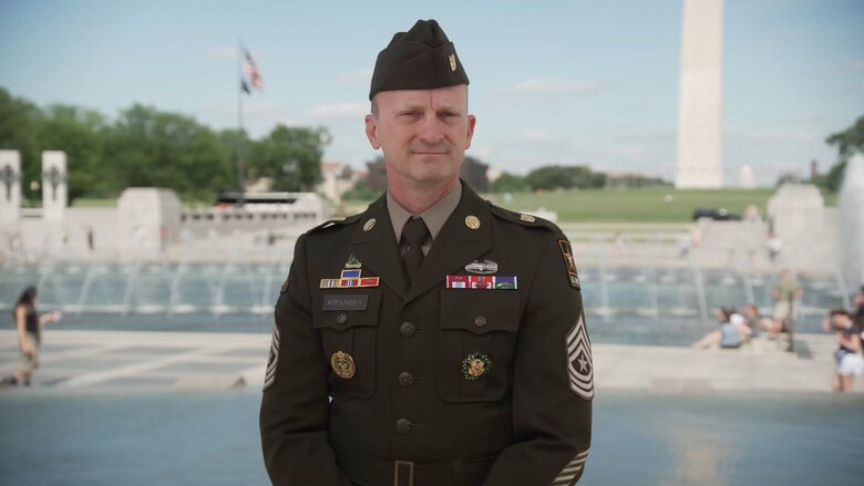 A soldier stands at a monument.