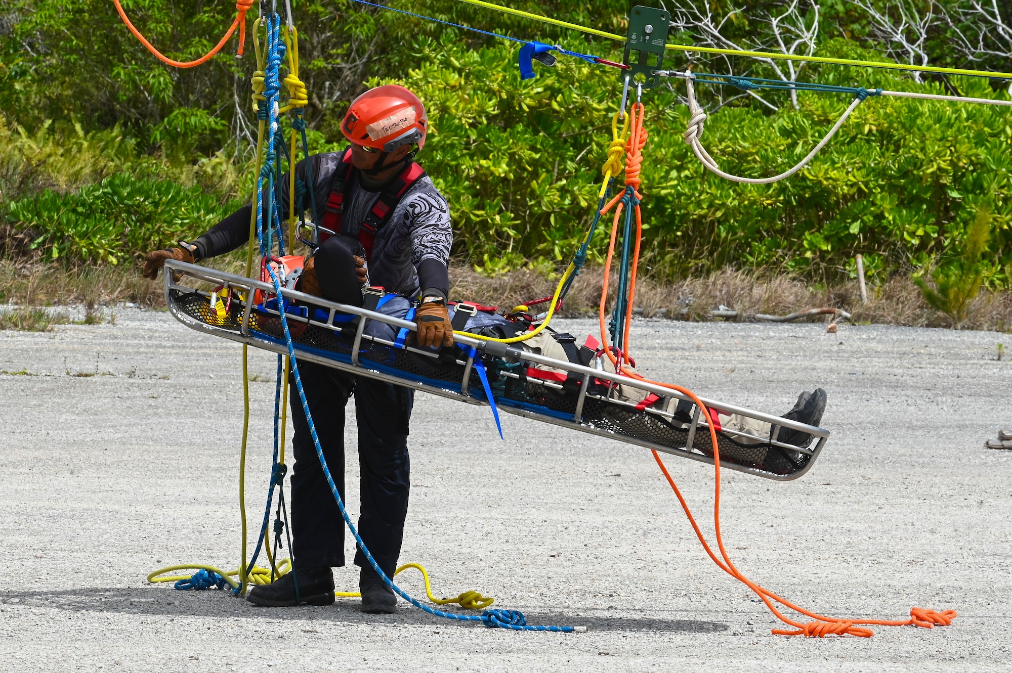 The Rapid Engineer Deployable Heavy Operational Repair Squadron Engineer Squadron, teaches students the importance of hooking the carabiner onto the victim at Andersen Air Force Base, Guam, May 7, 2025. This pick off rescue is performed in high angle environments, such as a cliff or a steep rock face.(U.S. Air Force photo by Airman 1st Class Joseph Maye)