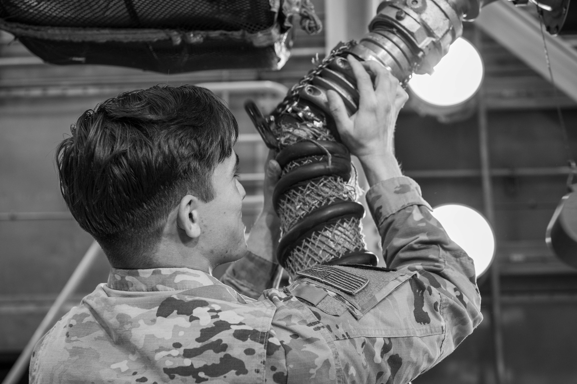 A member of the U.S. Air Force unclips a hose