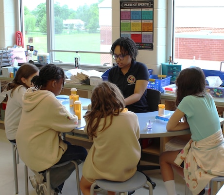 Captain Walter Francis Duke Elementary students were excited about the hands-on medication counting activity facilitated by HM2 Adia Moody at the Career Day hosted by the elementary school. HM2 Moody took the opportunity to explain her role as a pharmacy technician in the Navy by detailing the responsibilities of the position such as the importance of accurately filling prescriptions, compounding medications when needed, and maintaining meticulous records. Moody highlighted how these tasks directly contribute to Sailors, Marines, and their families receiving necessary medications for their health and well-being