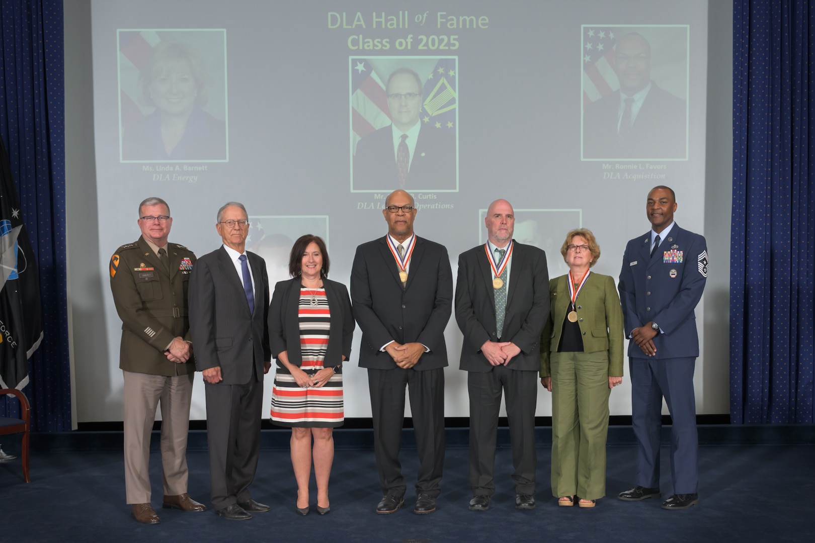 2025 DLA Hall of Fame inductees (from left) Air Force Lt. Gen. Earl Hedlund’s son, retired Navy Capt. John Hedlund; Larue “Scott” Rosbaugh’s widow, Kimberly Rosbaugh; Ronnie Favors; Jeffrey Curtis; and Linda Barnett