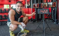A sweat-soaked Oregon Army National Guard Physician Assistant Maj. Tommy Vu points to the counter displaying 1,422 repetitions after completing his world record attempt for most hand release push-ups in one hour at West Coast Strength gym in West Salem, Ore., May 23, 2025.