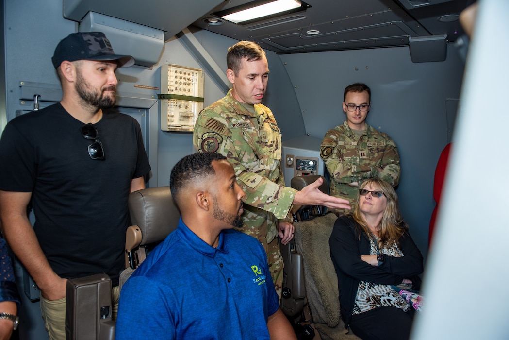 Local leadership tour the inside of an aircraft on the flight line