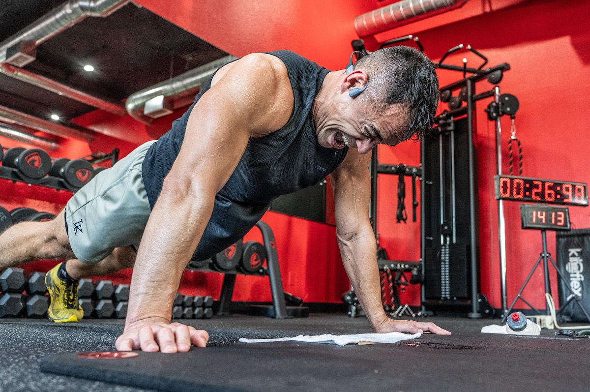 Oregon Army National Guard Physician Assistant Maj. Tommy Vu grimaces with maximum effort at the apex of a push-up as the counter shows 1,413 repetitions with just 26 seconds remaining in his world record attempt at West Coast Strength gym in West Salem, Ore., May 23, 2025.