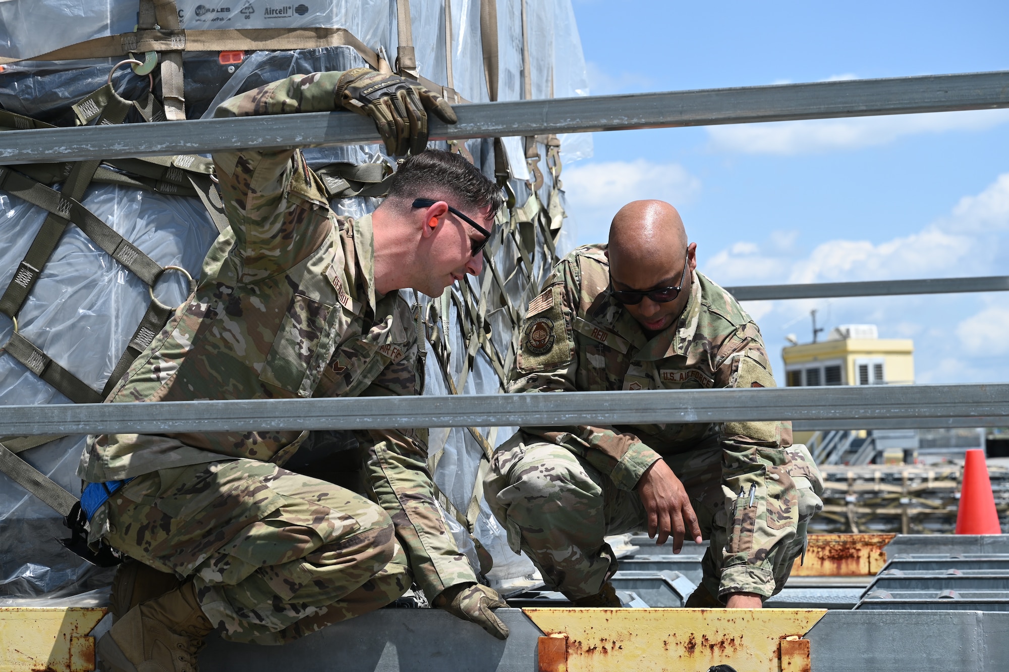 U.S. Air Force Master Sgt. Thomas Reid, right, 87th Aerial Port Squadron quality assurance, instructs Senior Airman Zechariah Gerardi, 87th APS ramp representative apprentice, on how to properly line up a pallet coming in from a 60K vehicle at Joint Base Charleston, S.C., April 10, 2025. Airmen with the 87th APS rotated with 437th APS Airmen, the active-duty unit, practicing the operation of the 60K and guiding it. (U.S. Air Force photo by Tech. Sgt. Joel McCullough)
