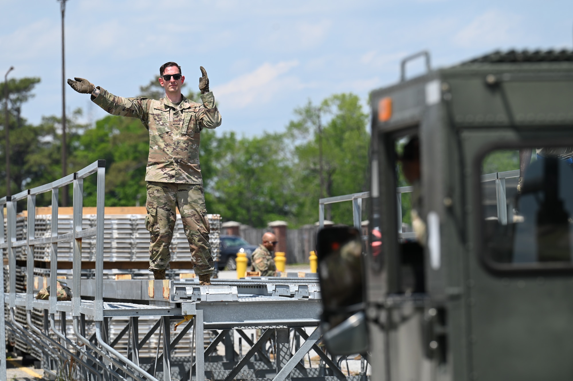 U.S. Air Force Senior Airman Zechariah Gerardi, 87th Aerial Port Squadron ramp representative apprentice, guides in a 60K vehicle using hand signals at Joint Base Charleston, S.C., April 10, 2025. APS Airmen practice guiding and operating the vehicles for hours to help ensure efficiency and comfortability. (U.S. Air Force photo by Tech. Sgt. Joel McCullough)