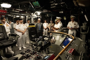 Cmdr. Bill Golden, center, commanding officer of the littoral combat ship USS Canberra’s (LCS 30) Blue Crew, gives a tour of the ship’s bridge in Manama, Bahrain, May 26. Canberra, an Independence variant of LCS, is deployed to the region to maintain regional maritime security in the Middle East region.
