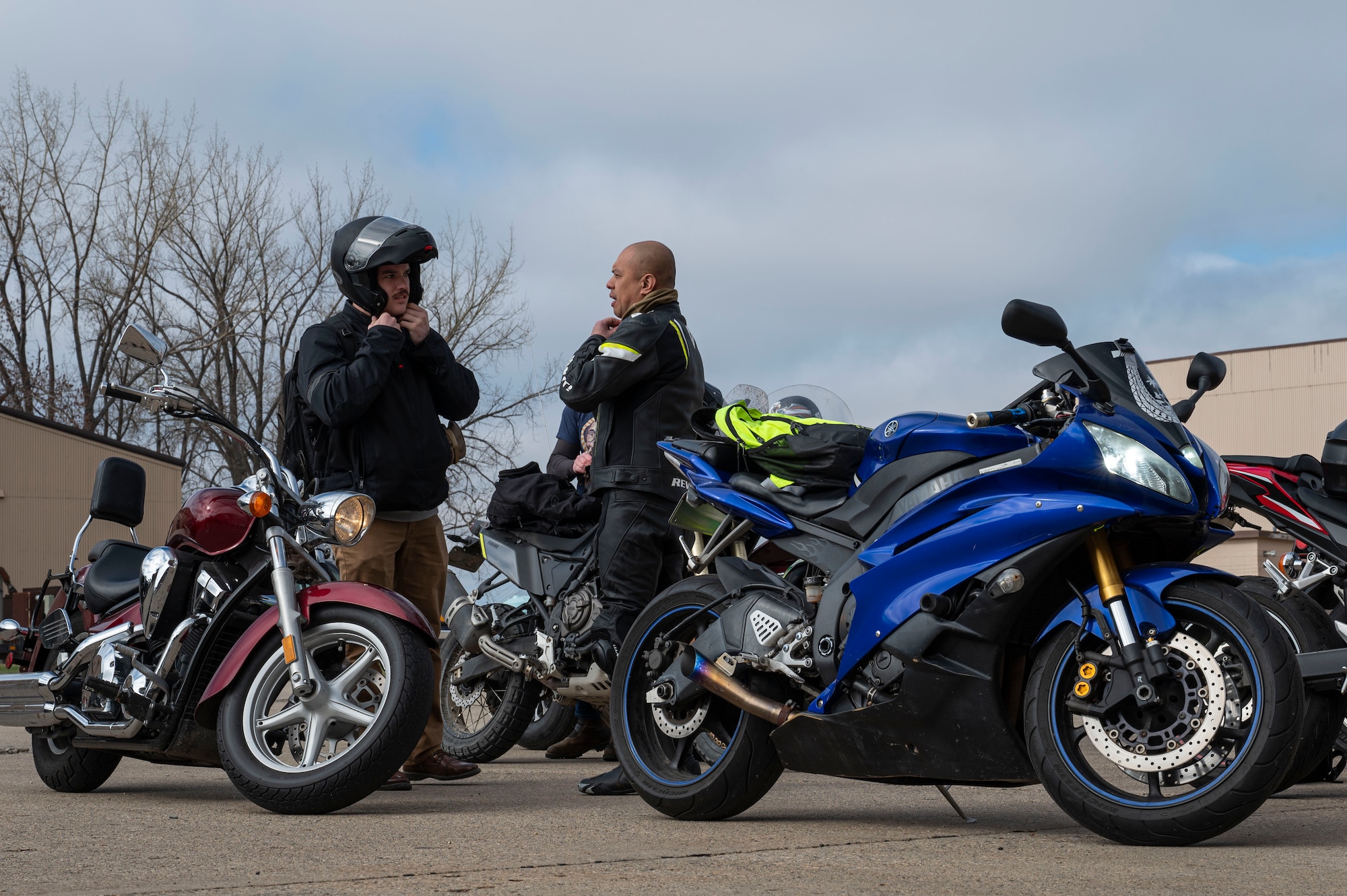 Tech. Sgt. Jacob Cruz, 319th Logistics Readiness Squadron vehicle maintenance quality assurance and Staff Sgt. Cody Rients, 319th LRS, fleet management non-commissioned officer in charge, don their helmets while getting ready for a motorcycle safety ride at Grand Forks Air Force Base, N.D., May 2, 2025. After the initial class, riders went through a pre-ride inspection to check for mechanical issues and potential hazards before the ride commenced. (U.S. Air Force photo by Airman 1st Class Emma Funderburk)
