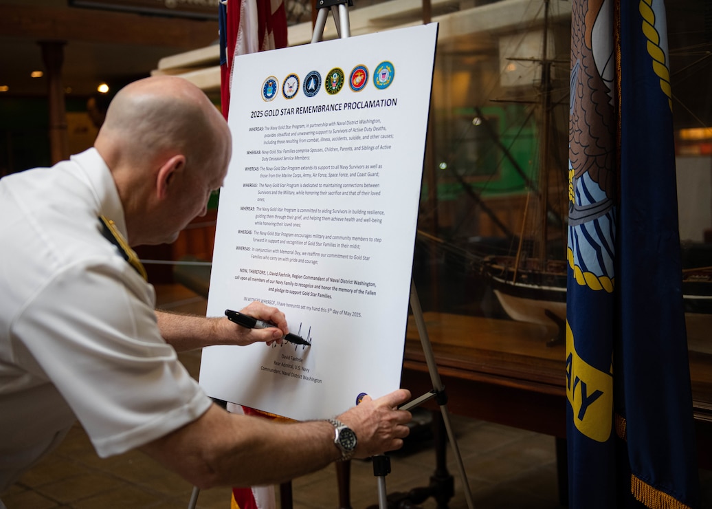 WASHINGTON (May 5, 2025) - Rear Adm. David Faehnle, commandant, Naval District Washington, signs a Gold Star Remembrance proclamation at the Navy Museum onboard the Washington Navy Yard. The Navy Gold Star Program provides support to surviving family members of Sailors who died while on active duty, regardless of your loved one's military branch, location, or manner of death. (U.S. Navy Photo by Mass Communication Specialist 1st Class Griffin Kersting)