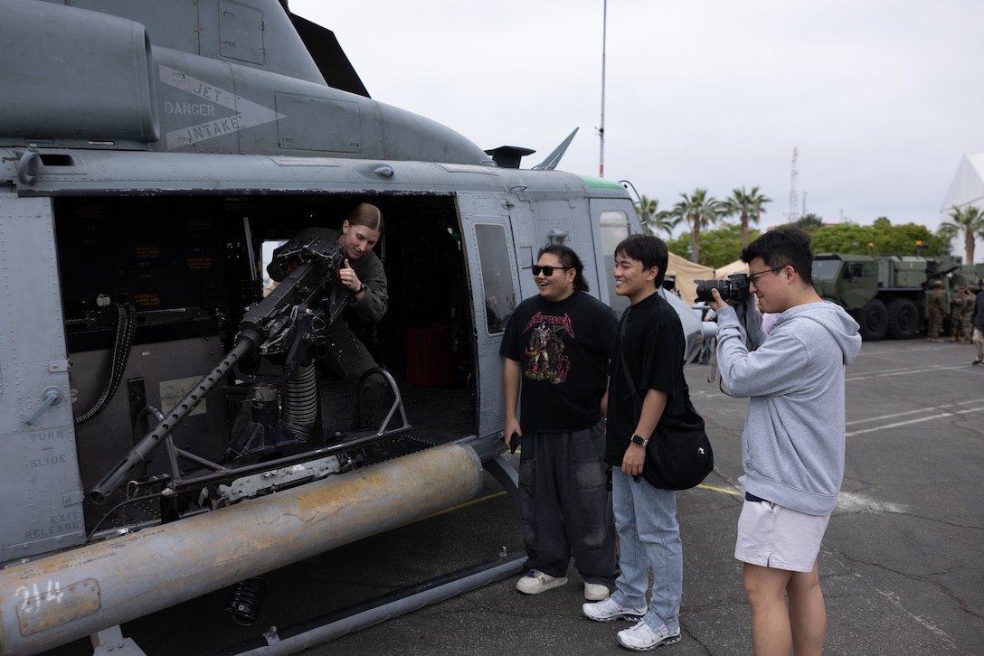 U.S. Marine Corps Lance Cpl. Isaac Rodriguez, left, a light armored reconnaissance vehicle crewman with 3rd Light Armored Reconnaissance Battalion, 1st Marine Division, poses for a photo with a local during Los Angeles Fleet Week in Los Angeles, May 23, 2025.