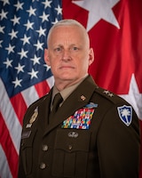 MG Stilwell in front of American flag and 2 star flag
