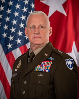 MG Stilwell in front of American flag and 2 star flag