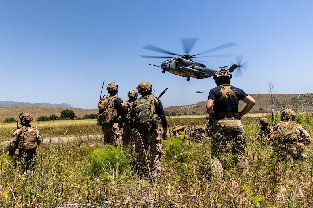 U.S. Marines with 3rd Battalion, 1st Marines, 1st Marine Division, post security as a CH-53E Super Stallion attached to Marine Heavy Helicopter Squadron (HMH) 361 arrives at a landing zone during a tactical recovery of aircraft and personnel course hosted by Amphibious Raids Branch, Expeditionary Operations Training Group, I Marine Expeditionary Force, at Marine Corps Base Camp Pendleton, California, May 15, 2025.