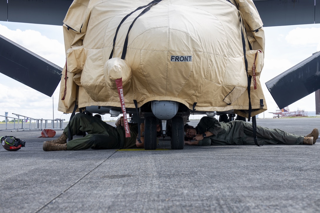 U.S. Marine Corps Lance Cpl. Justin Gonzales, left, an MV-22B Osprey flight line mechanic and Capt. John Kleczkowski, right, an MV-22 Osprey pilot, both with Marine Medium Tiltrotor Squadron (VMM) 364, Marine Aircraft Group 39, 3rd Marine Aircraft Wing, inspect the front landing gear of a U.S. Marine Corps MV-22B Osprey assigned to VMM-364 during KAMANDAG 9 at Clark Air Base, Angeles, Philippines, May 26, 2025.