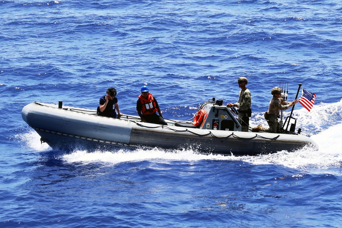 Coast Guardsmen on a small boat navigate over the water on a sunny day.