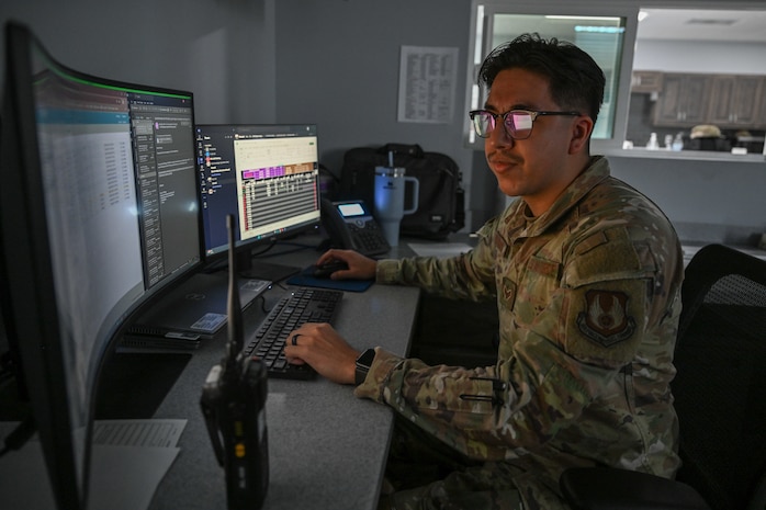An Airman sits at a computer