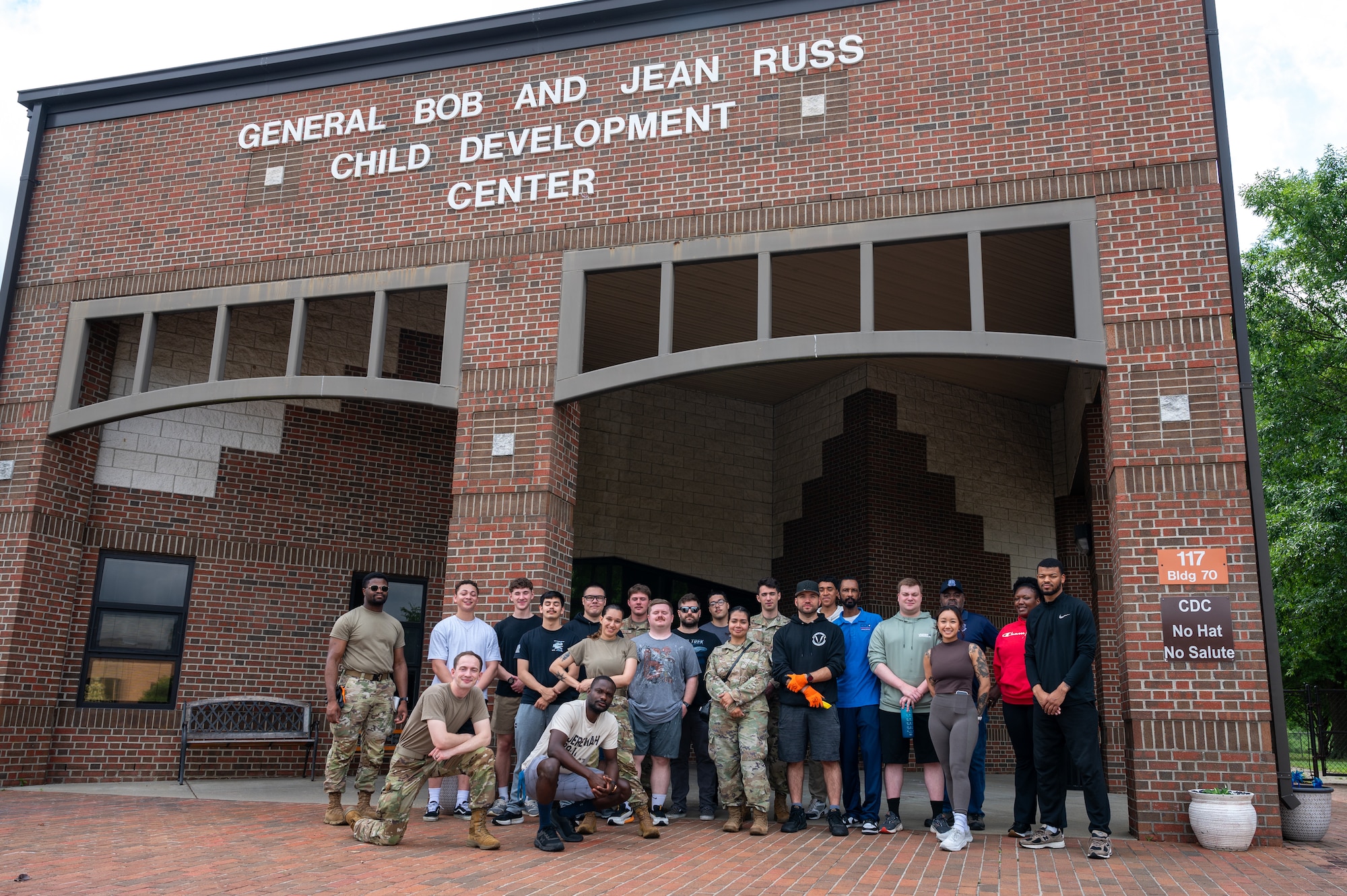 Posed photo of a group of volunteers, some in uniform and some in civilian clothing, in front of the CDC brick building.