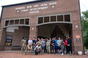 Posed photo of a group of volunteers, some in uniform and some in civilian clothing, in front of the CDC brick building.