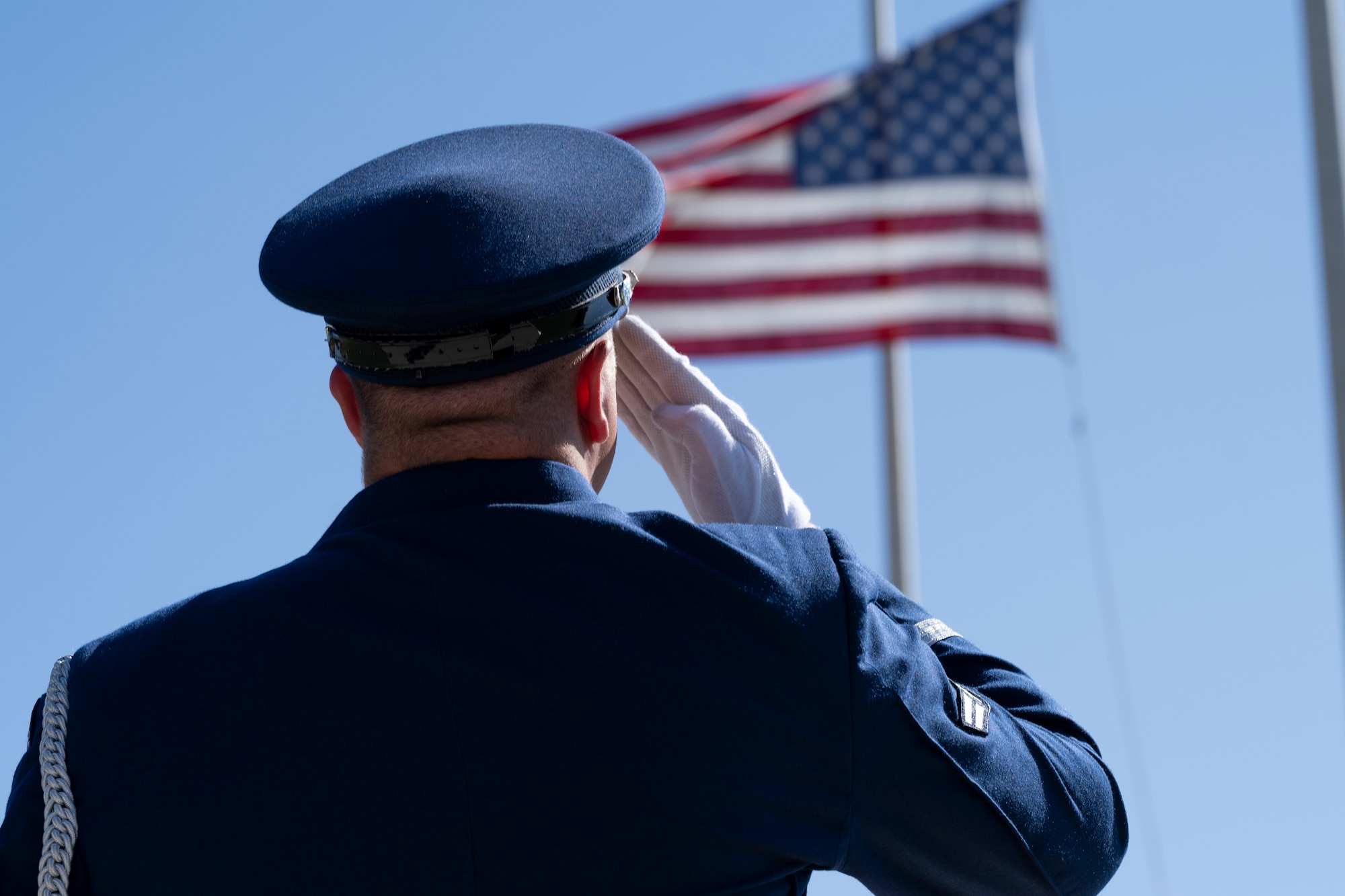 A member of the Steel Talons Honor Guard salutes the flag during retreat as part of a Memorial Day ceremony at Holloman Air Force Base, New Mexico, May 22, 2025. During the ceremony, the base honor guard folded and dressed the installation’s flag before presenting it to the family members of fallen U.S. service members in attendance. (U.S. Air Force photo by Tech. Sgt. Victor J. Caputo)