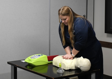 Maylis Burns, a basic life support instructor and pharmacy tech at Barquist Army Health Clinic, shows how to do CPR chest compressions and operate an AED during AMLC’s safety stand-down May 14 at Fort Detrick, Maryland.