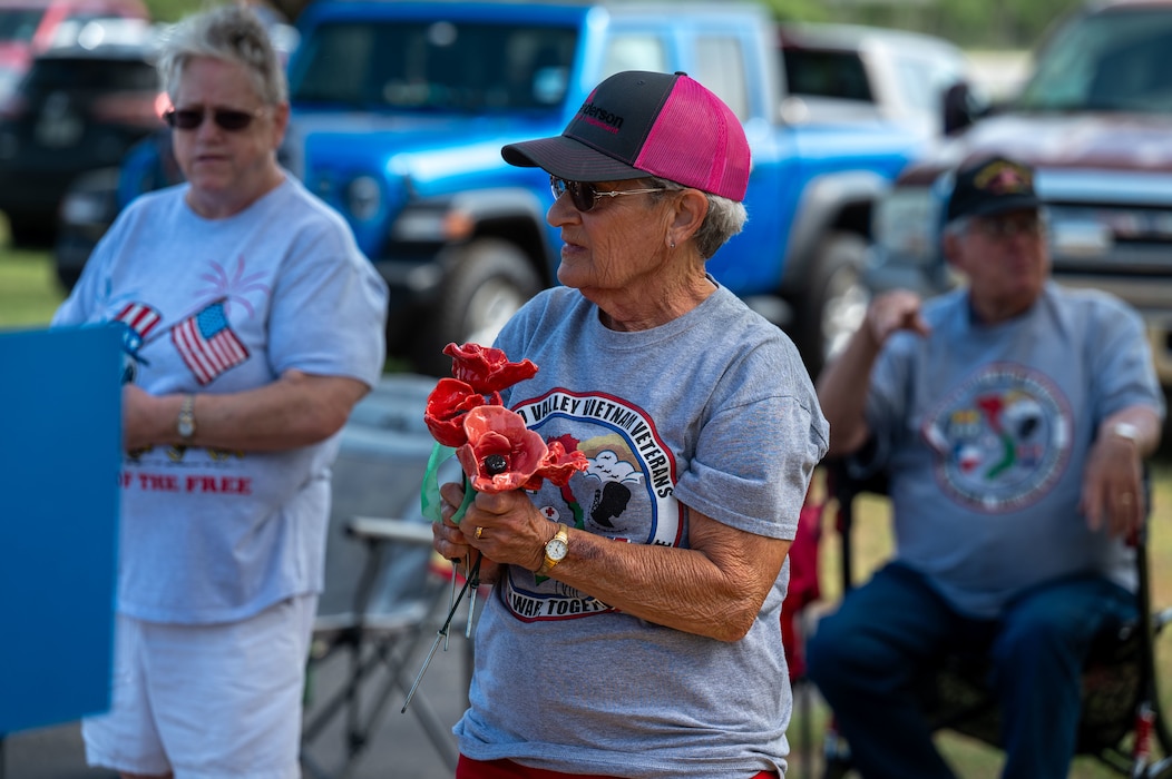 Attendee at the Concho Valley Vietnam Veterans Memorial receives poppies at the San Angelo Regional Airport - Mathis Field, San Angelo, Texas, May 26, 2025.  Poppies are a symbol recognized after World War 1 meant to memorialize the service members who lost their lives while at war. (U.S. Air Force photo by Airman 1st Class James Salellas)
