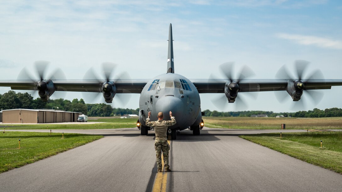 An airman from the 123rd Contingency Response Group marshals a C-130J Super Hercules from the Kentucky Air National Guard down a taxiway at Murray-Calloway County Airport in Murray, Ky., May 14, 2025, as part of Exercise Grindstone, a major earthquake-response simulation.