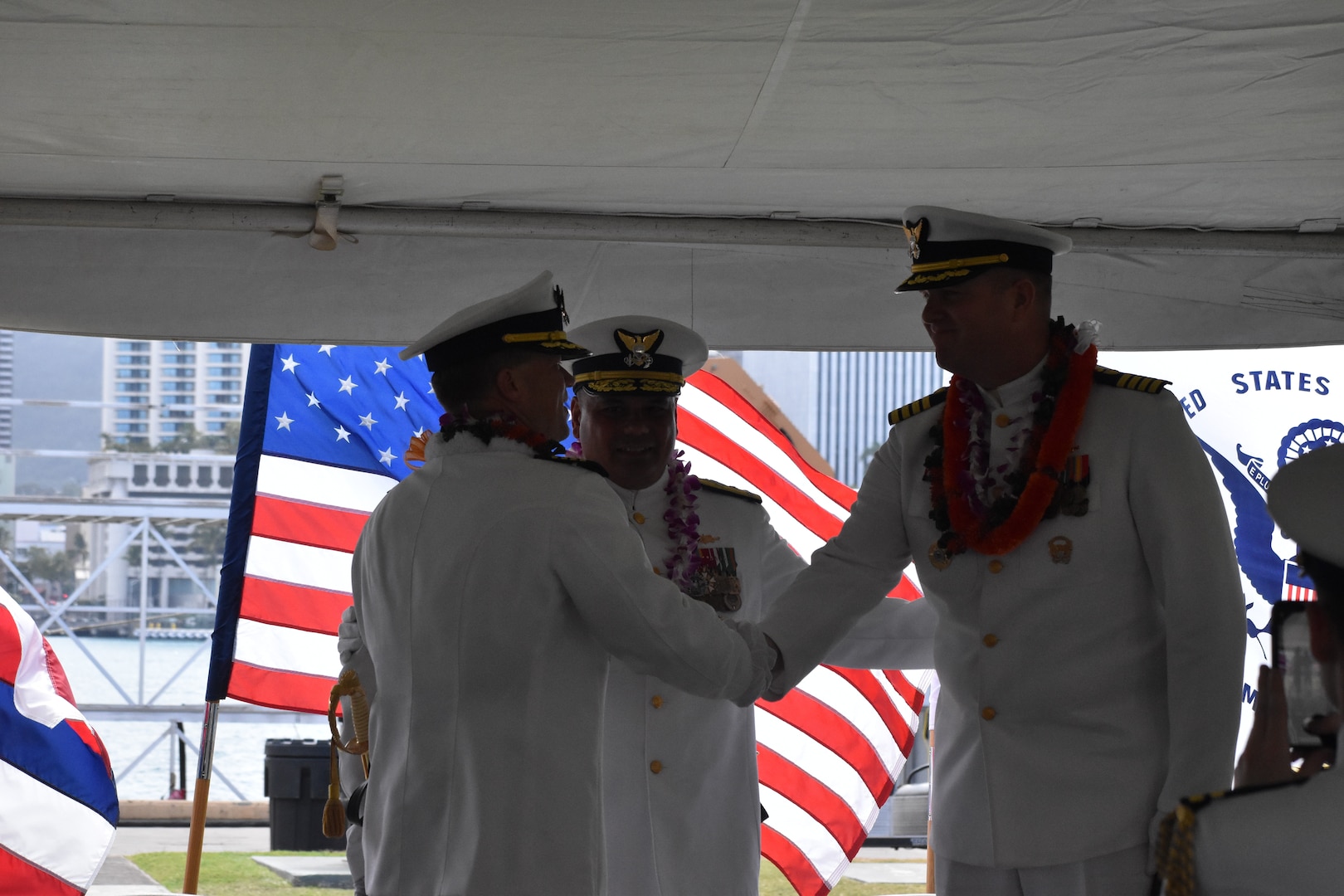 Capt. Brian Whisler, commanding officer of U.S. Coast Guard Cutter Midgett (WMSL 757) shakes hands with Capt. Matthew Rooney during the change of command ceremony in Honolulu, May 23, 2025. Commissioned in 2019, Midgett is named after the Midgett family and is one of two Coast Guard legend-class National Security Cutters homeported in Honolulu. (U.S. Coast Guard photo by Ens. Harlan Brady).