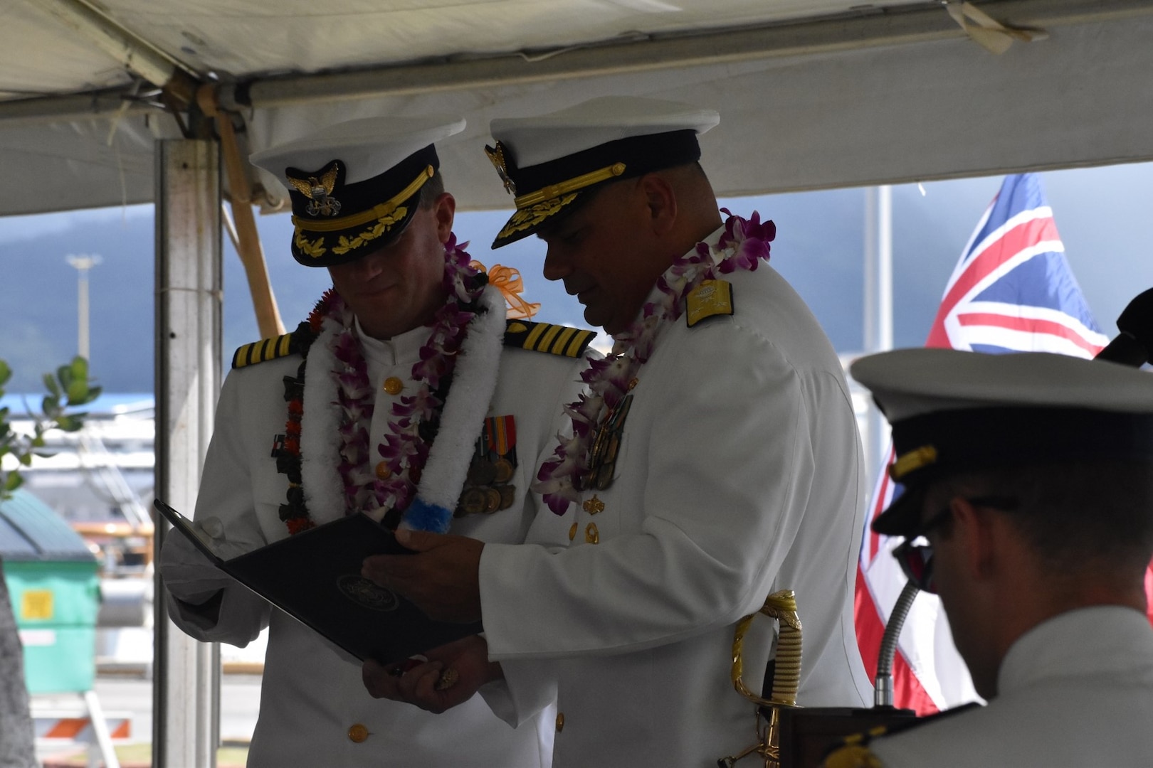 Vice Adm. Andrew Tiongson, commander, U.S. Coast Guard Pacific Area, presents Capt. Matthew Rooney with an award during the change of command ceremony for U.S. Coast Guard Cutter Midgett (WMSL 757) in Honolulu, May 23, 2025. Commissioned in 2019, Midgett is named after the Midgett family and is one of two Coast Guard legend-class National Security Cutters homeported in Honolulu. (U.S. Coast Guard photo by Ens. Harlan Brady).