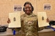 U.S. Air Force Senior Airman Dominique Henry, contracting specialist assigned to the 5th contracting squadron, poses with her score sheet at Minot Air Force Base, May 8, 2025. Henry posed after receiving a passing grade for her shooting at Combat Arms Training and Maintenance training course.(U.S. Air Force photo by Airman 1st Class Anthony Ramey)