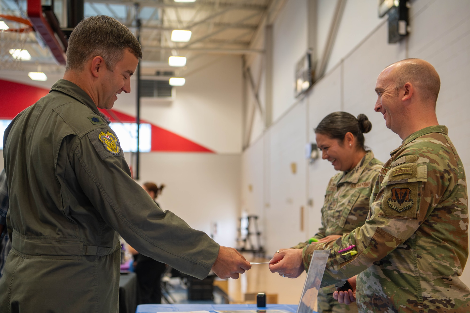 U.S. Air Force Lt. Col Erik Flippin, 325th Fighter Wing inspector general, talks with Master Sgt. Brandon Pelfrey, 325th Operational Support Squadron first sergeant, at the Operation Warm Heart table at the Elevate Expo at Tyndall Air Force Base, Florida.