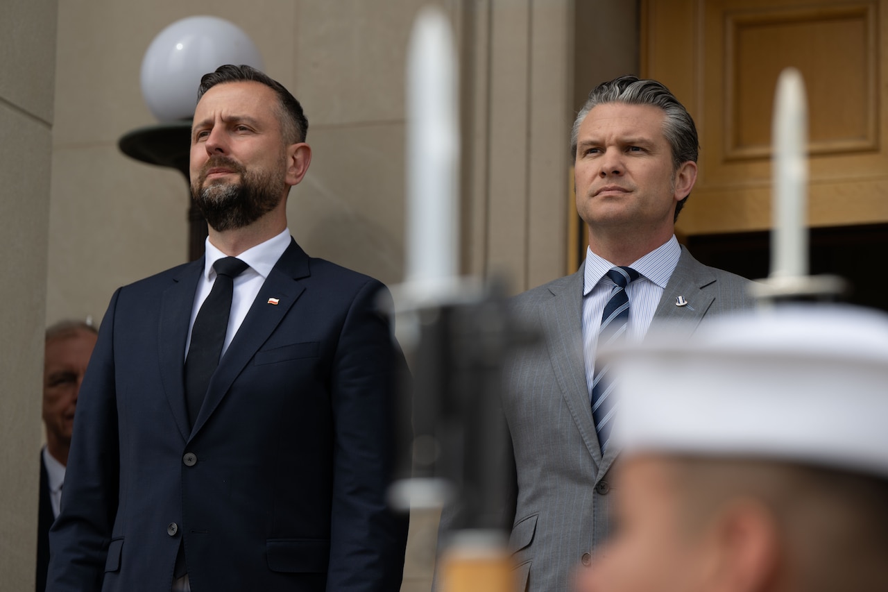 Two men stand on the steps of the Pentagon during a ceremony.