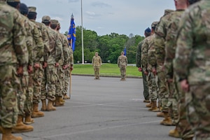 Airmen stand in formation as they receive a command from the commander of troops.