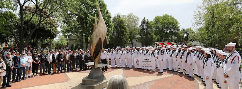 Local residents, veterans and service members gather at the eternal Flame at Memorial Park following the annual Memorial Day parade and ceremony in Arlington Heights, Illinois, May 26, 2025.