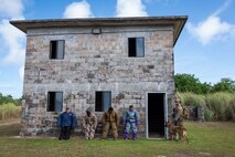U.S. Air Force Staff Sgt. Russell Postmus, right, 647th Security Forces Squadron military working dog handler assigned to Hickam Air Force Base, Hawaii, responds to a simulated noise complaint during a Pacific Air Forces Advanced Combat Skills Assessment K9 competition at Andersen Air Force Base, Guam, May 20, 2025.