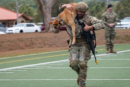 U.S. Air Force Senior Airman Nikolas Somoza, 18th Security Forces Squadron military working dog handler assigned to Kadena Air Base, Japan, runs with Dina, 18 SFS military working dog, during the dog carry portion of a Pacific Air Forces Advanced Combat Skills Assessment K9 competition at Andersen Air Force Base, Guam, May 19, 2025.