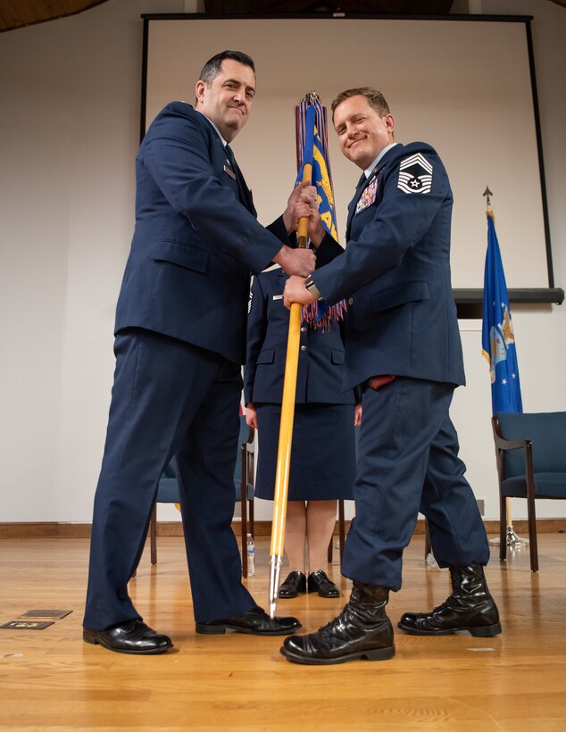 Chief Master Sgt. Blair Baerny, right, accepts the 123rd Airlift Wing guidon from Col. Matthew Quienichet, 123rd Airlift Wing commander, signifying Baerny’s assumption of the role of wing command chief during a ceremony at the Kentucky Air National Guard Base in Louisville, Ky., April 13, 2025. Baerny replaces Chief Master Sgt. Steven Best, who was named state command chief for the Kentucky Air National Guard. (U.S. Air National Guard photo by Master Sgt. Joshua Horton)