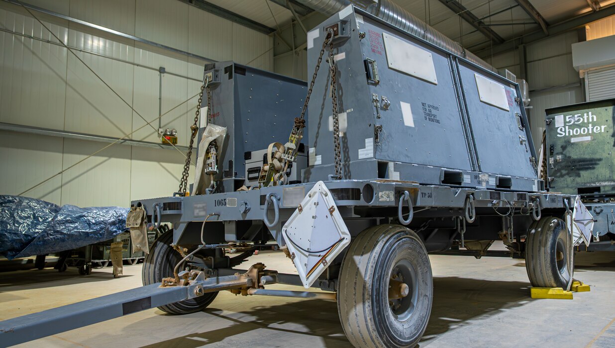 A trailer is parked in a hangar.