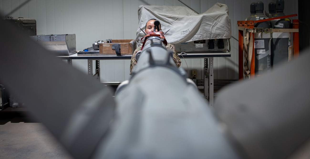 An Airman looks down an AIM-9x missile.