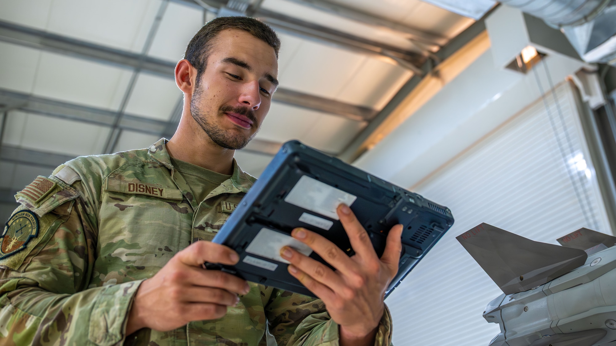 An Airmen reads a tablet.