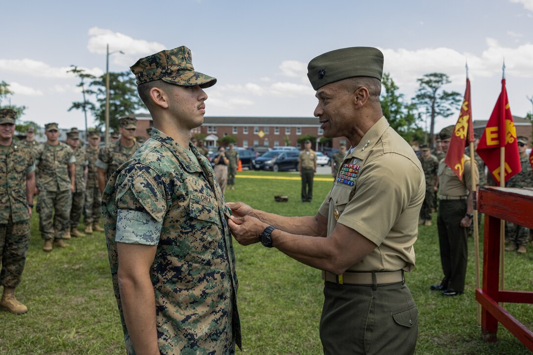 U.S. Marine Corps Cpl. David Chica, a maintenance management specialist with 2d Battalion, 6th Marine Regiment, 2d Marine Division, receives a Navy and Marine Corps Achievement Medal from Lt. Gen. Calvert L. Worth Jr., the commanding general of II Marine Expeditionary Force during an award ceremony on Camp Lejeune, North Carolina, May 23, 2025. The II MEF Lieutenant General “Chesty” Puller Award is awarded to units within the II MEF that showed outstanding ability and superior performance in supporting the mission of the II MEF within the past year. (U.S. Marine Corps photo by Lance Cpl. Judith Ann Lazaro)