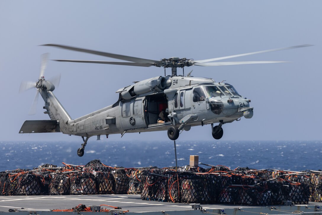 A U.S. Navy MH-60S Seahawk with Helicopter Sea Combat Squadron 26, delivers cargo to the San Antonio-class amphibious transport dock ship USS San Antonio (LPD 17), during a replenishment-at-sea, as part of Iwo Jima Amphibious Ready Group Marine Expeditionary Unit exercise, while underway in the Atlantic Ocean, May 21, 2025. During ARGMEUEX, the 22nd MEU, aboard IWOARG shipping, conducts training in support of various mission essential tasks that enhance operational readiness and lethality as a unified IWOARG/22 MEU team. (U.S. Marine Corps photo by 2nd Lt. Emma Shattuck)