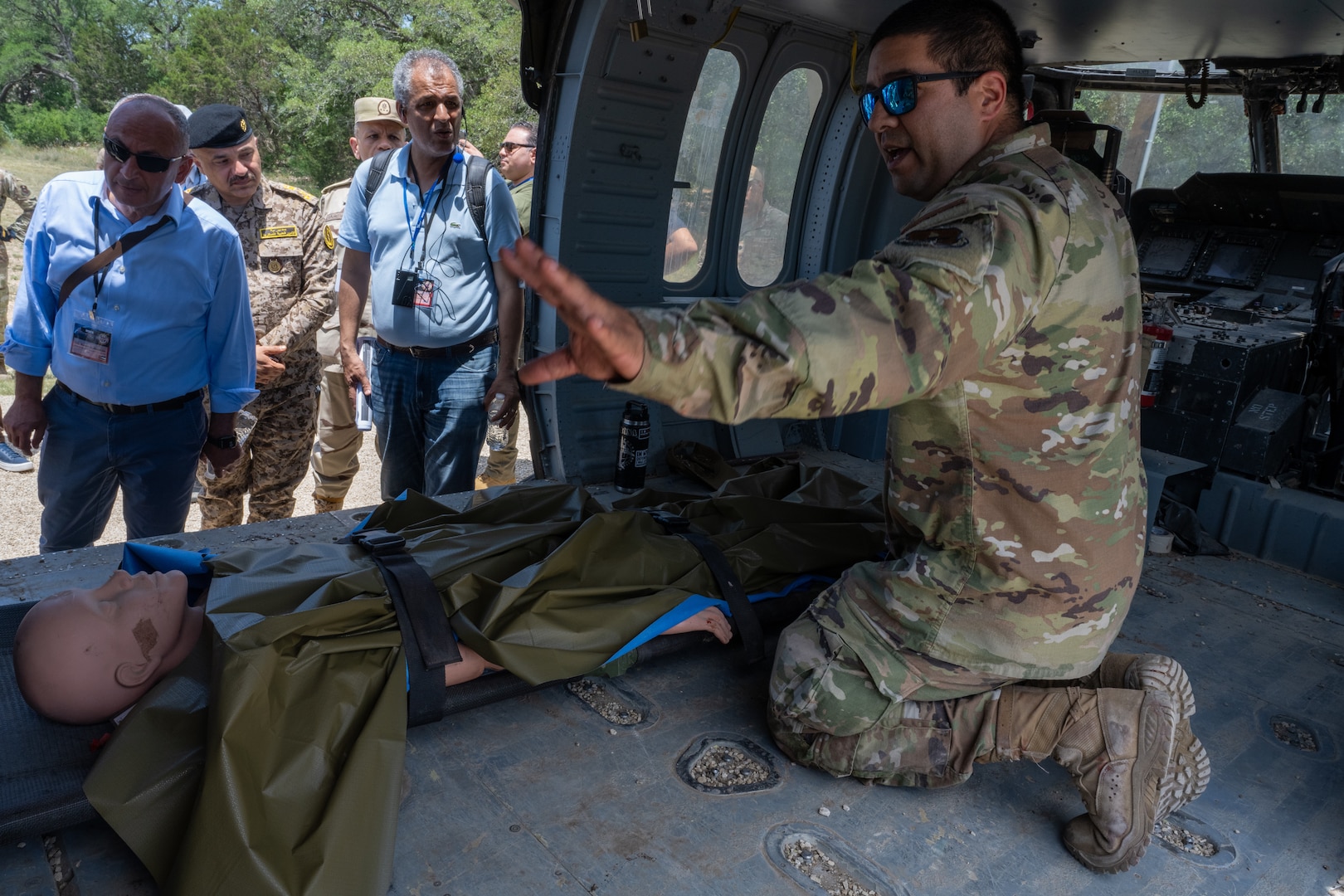 Staff Sgt. Gerardo Corona, 937th Training Support Squadron instructor, briefs participants of the 2025 U.S. Central Command Medical Security Cooperation Exchange on aerial medical evacuation procedures when using a helicopter at the Medical Readiness Training Center on Camp Bullis Military Training Reservation, Joint Base San Antonio – Fort Sam Houston, May 14, 2025.  Along with MEDEVAC, the USCENTCOM MSCE attendees toured different parts of the MRTC campus where they saw different demonstrations and capabilities included Tactical Combat Casualty Care, a simulator able to create different scenarios for personnel to train in and toured facilities design to be mobile for rapid response medical care. (U.S. Air Force photo by Joshua J. Garcia)