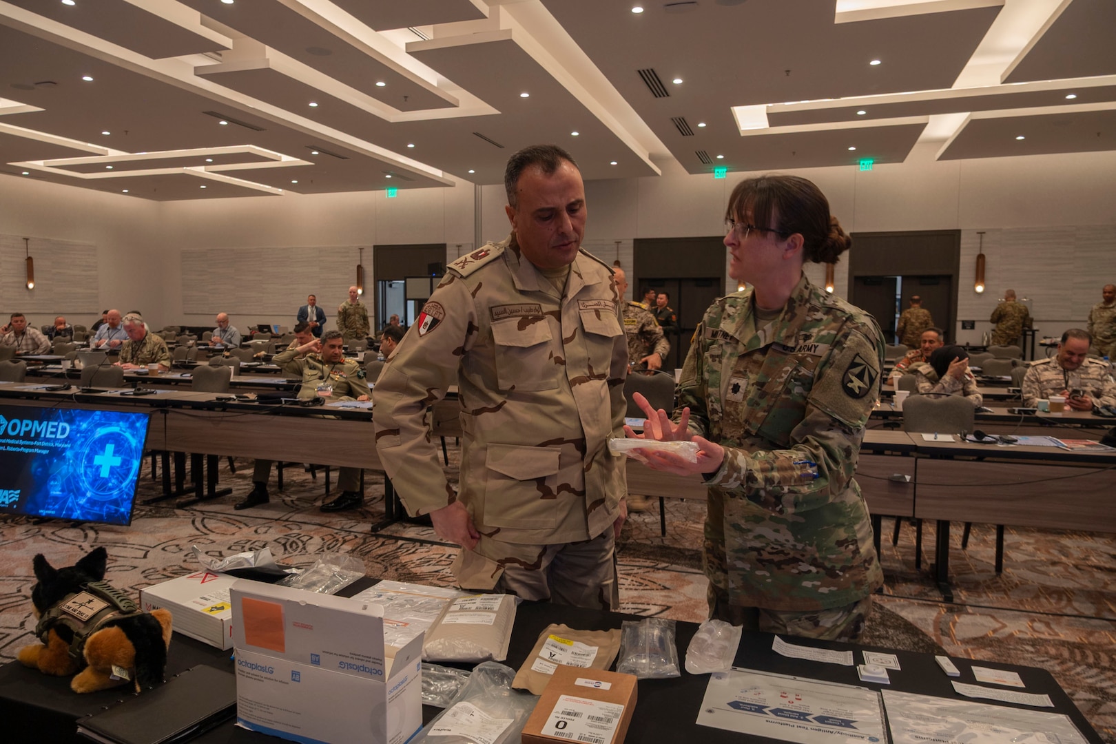 U.S. Army Lt. Col. Andrea Mountney, military deputy project manager with Operational Medical Systems Program Management Office, speaks with medical professionals from collaborating countries during the 2025 Medical Security Cooperation Exchange, San Antonio, Texas, May 15, 2025. OPMED, a vital component of the Defense Health Agency, is focused on enhancing Warfighter lethality and readiness. OPMED develops and delivers next generation, world-class medical capabilities that empower combatant commanders in Large Scale Combat Operations, particularly within austere environments. (Defense Health Agency Photo by Cameron Parks/Released)
