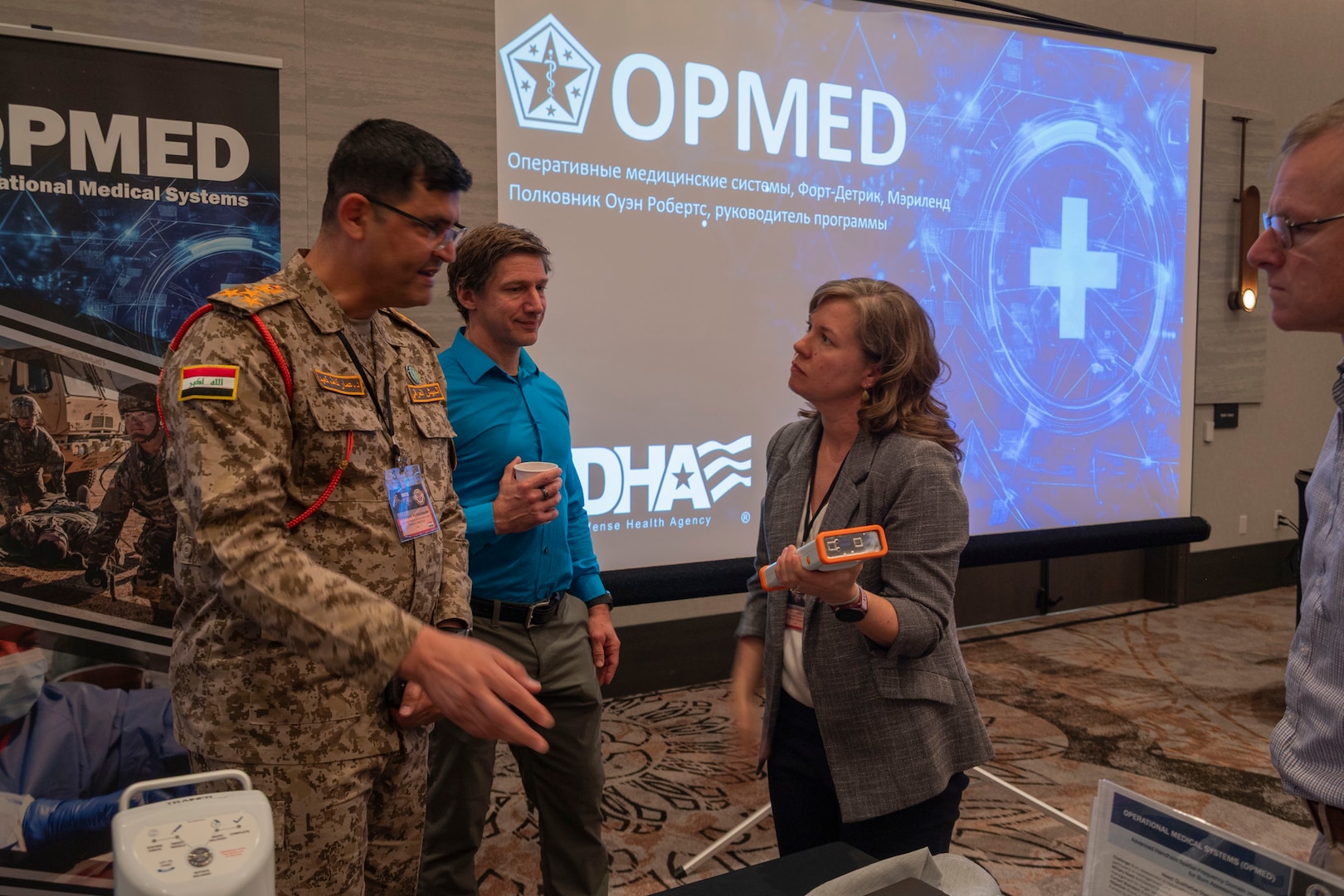 Kristin Jones-Maia, a product manager with Operational Medical Systems Program Management Office, speaks to medical professionals from collaborating countries during the 2025 Medical Security Cooperation Exchange, San Antonio, Texas, May 15, 2025. OPMED, a vital component of the Defense Health Agency, is focused on enhancing Warfighter lethality and readiness. OPMED develops and delivers next generation, world-class medical capabilities that empower combatant commanders in Large Scale Combat Operations, particularly within austere environments. (Defense Health Agency Photo by Cameron Parks/Released)