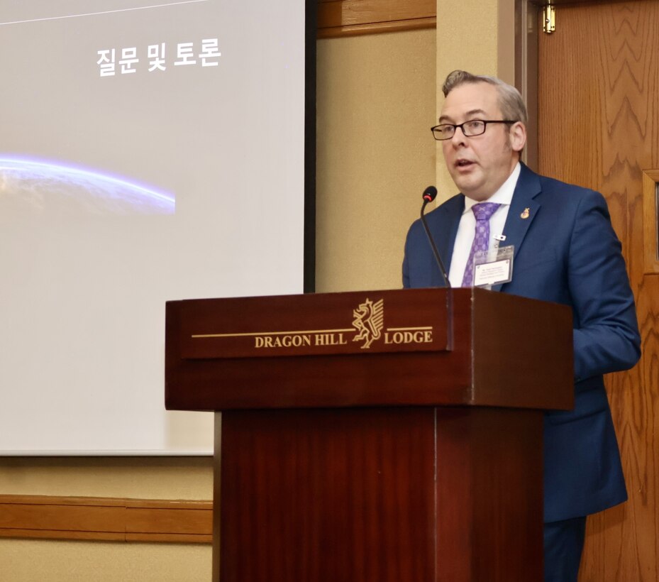 Mr. Todd Pennington (INSS) speaks behind a podium  and presents on Space and Law in Competition and Conflict at the Northeast Asia Operations and International Law Conference, presented by the Korea Tri-Command SJA Office.