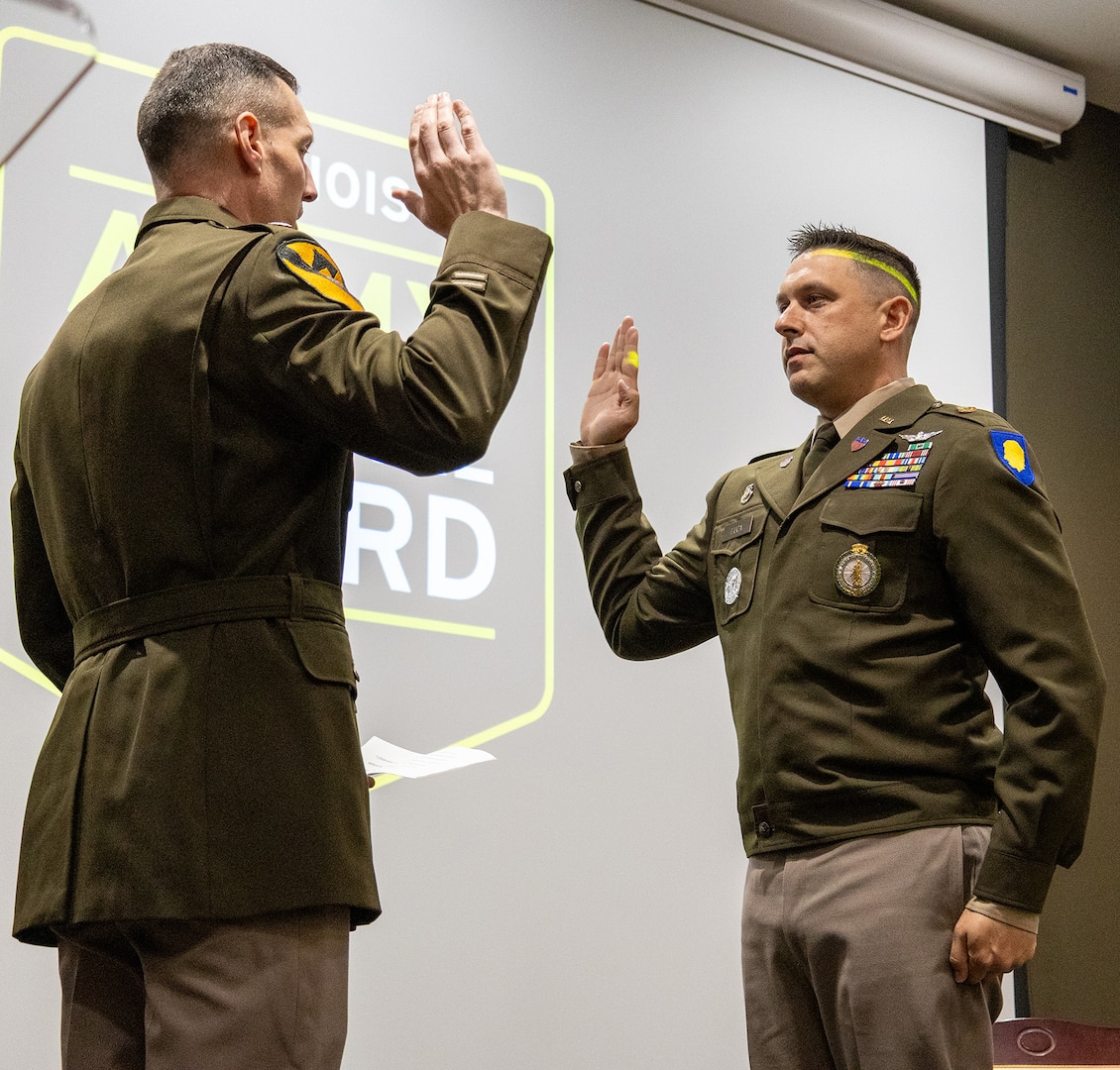Lt. Col. Lance Frail, Commander, Recruiting and Retention Battalion, administers the oath of office to newly commissioned 2nd Lt. Thomas Luca II during a commissioning ceremony May 17 at the Illinois Military Academy, Camp Lincoln, Springfield.